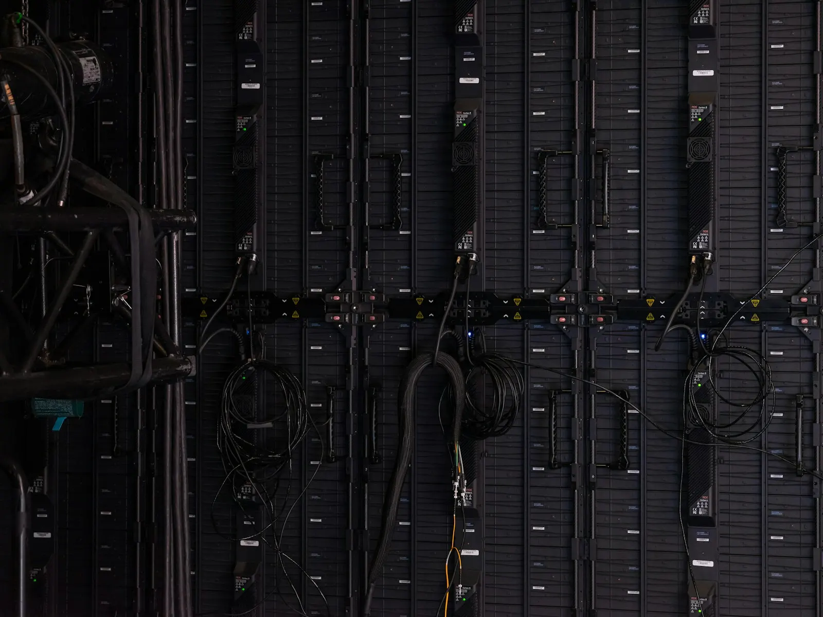 Black cables and wires connected to the back of modular LED display panels — illustrative image