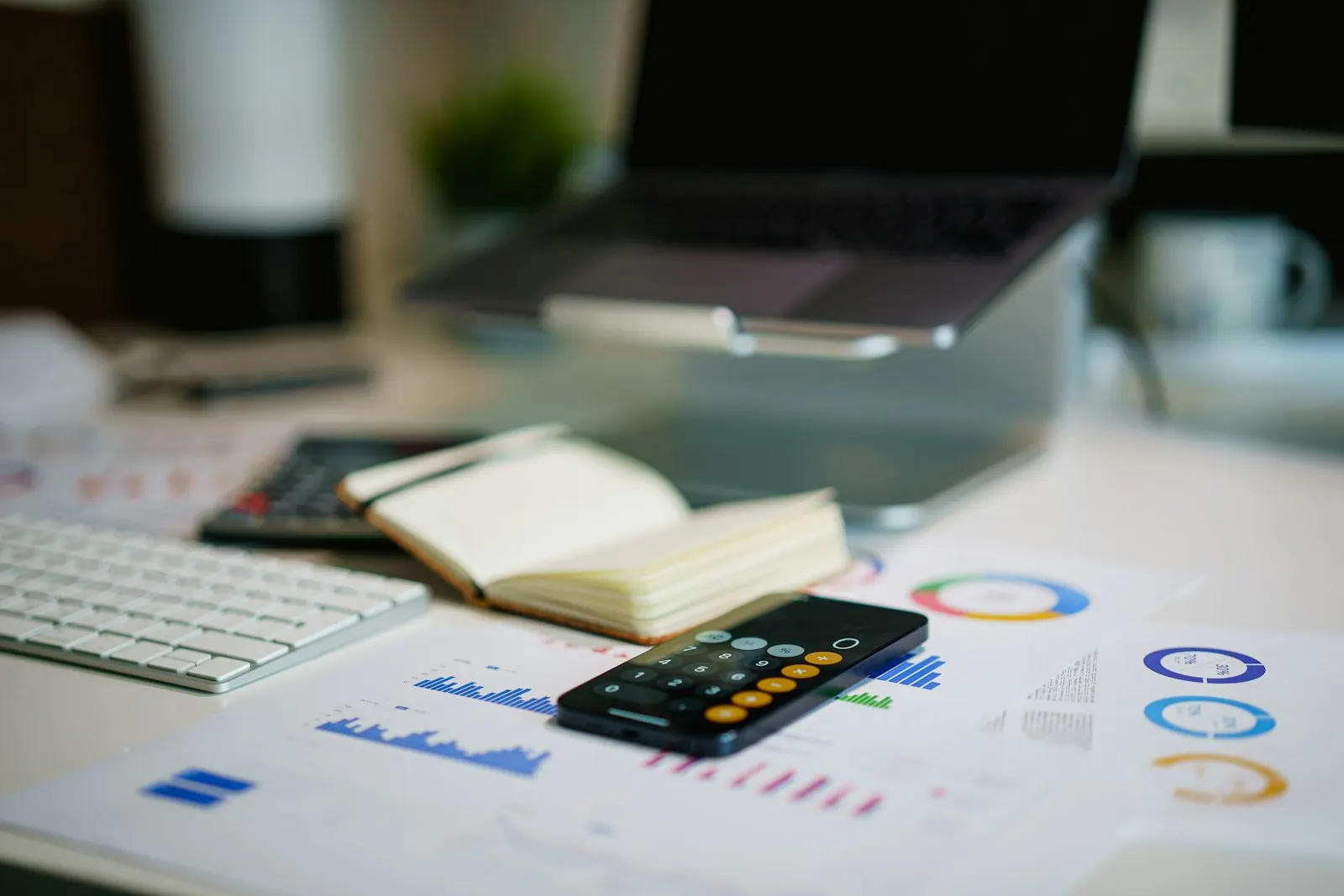 office desk with smartphone and financial charts — illustrative image
