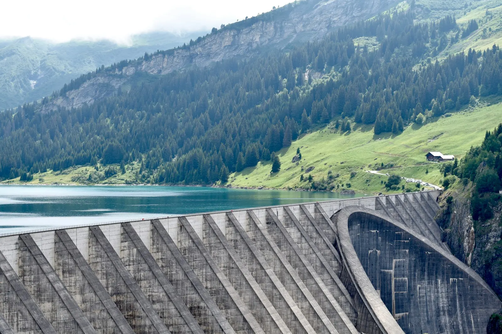 Technische Staumauer in einer Berglandschaft – Symbolmotiv