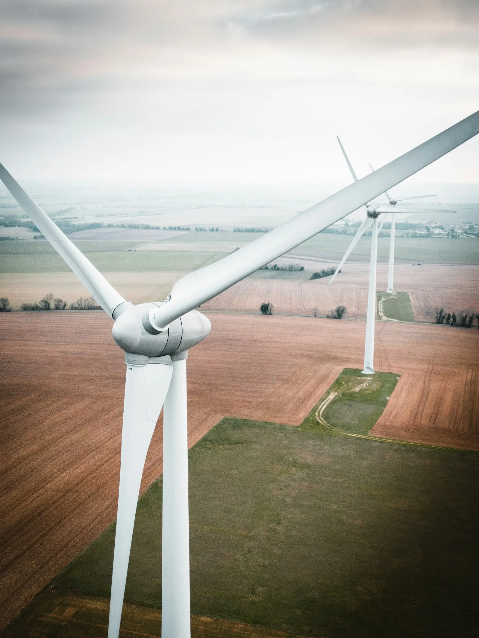 Turbina wiatrowa na tle terenów rolniczych, zdjęcie ilustracyjne